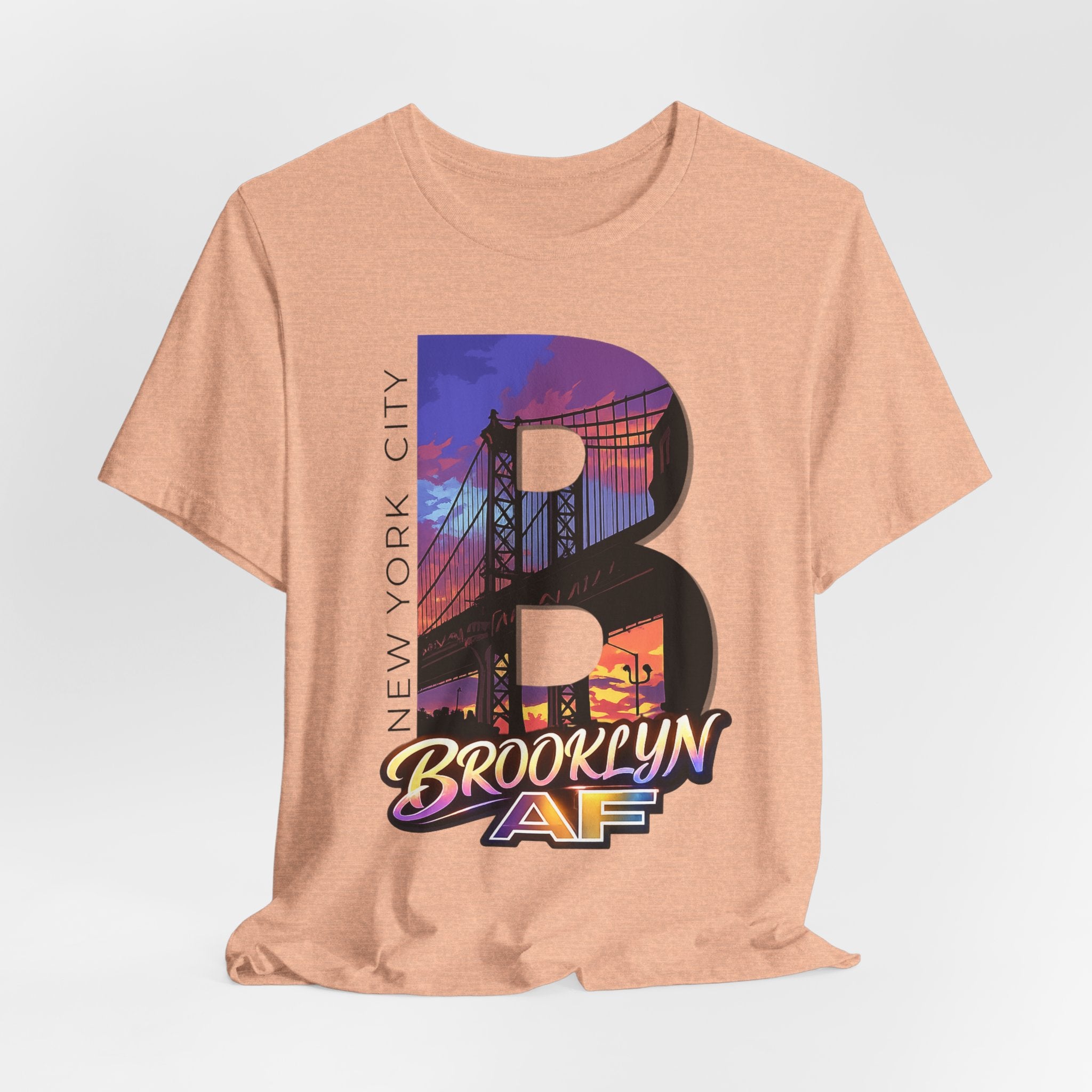 Heather Peach tee on a mannequin torso, front view, showing the "B" Brooklyn Bridge sunset skyline graphic and logo.