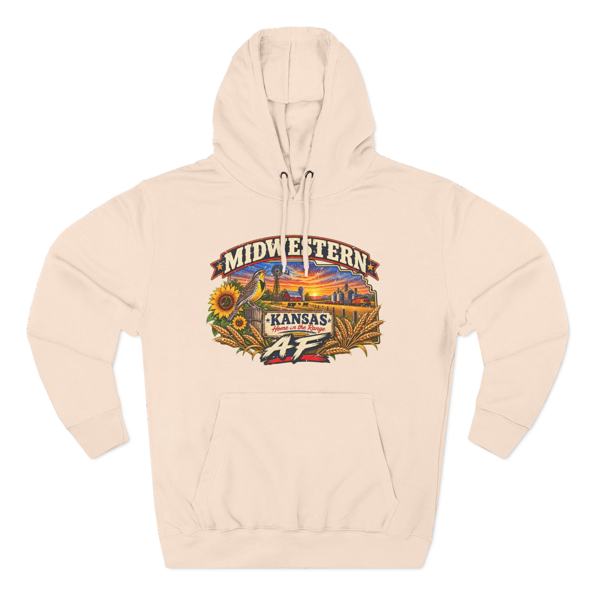 Pale pink Kansas AF hoodie laid flat, wheat and sunflowers framing the sunset