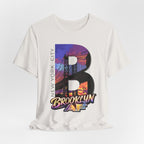 White tee, flat lay, front view, showing the oversized "B" Brooklyn Bridge sunset skyline graphic and "Brooklyn AF" logo.