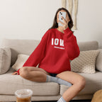 Woman relaxing on a sofa in the red personalized Iowa sweatshirt with varsity IOWA lettering