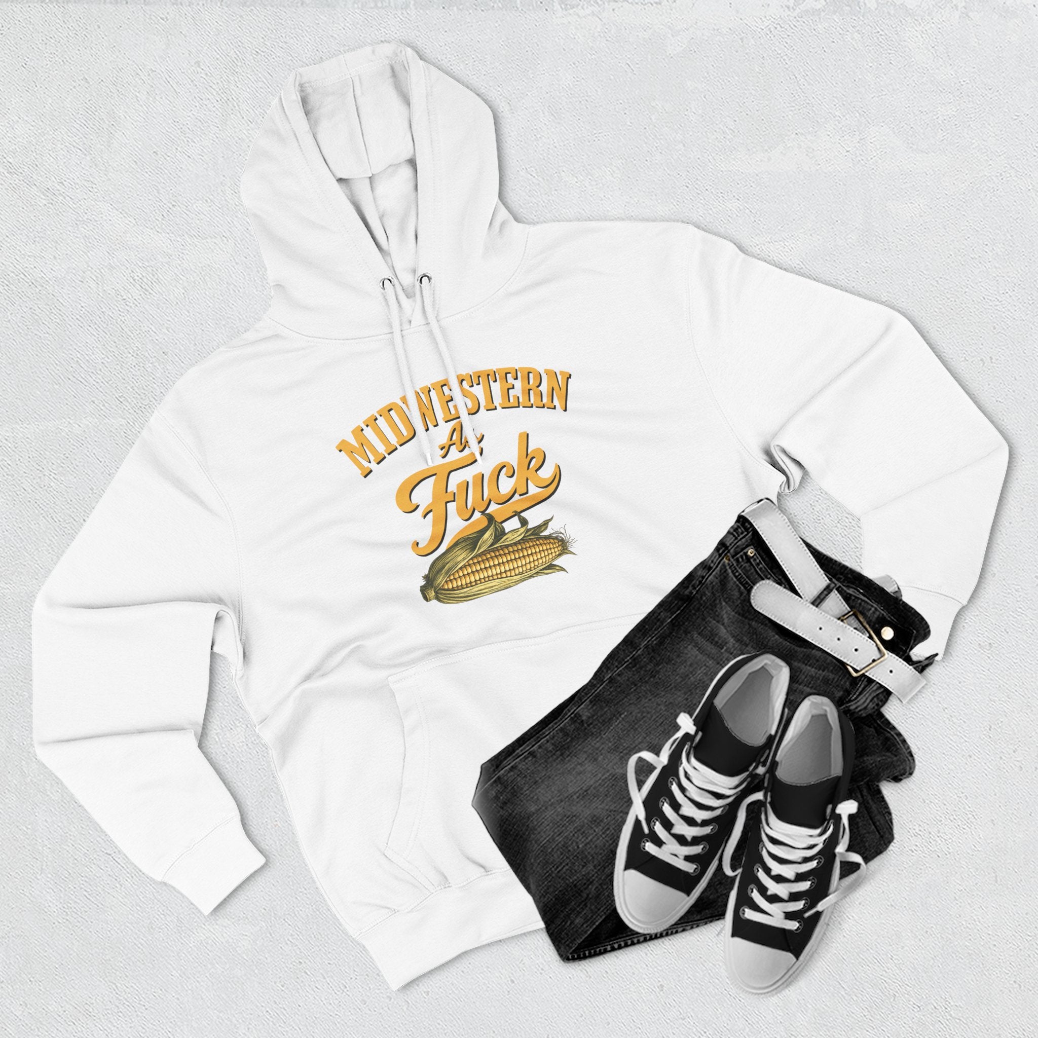 White hoodie styled flat lay paired with dark jeans, black high-top sneakers, and a white belt.