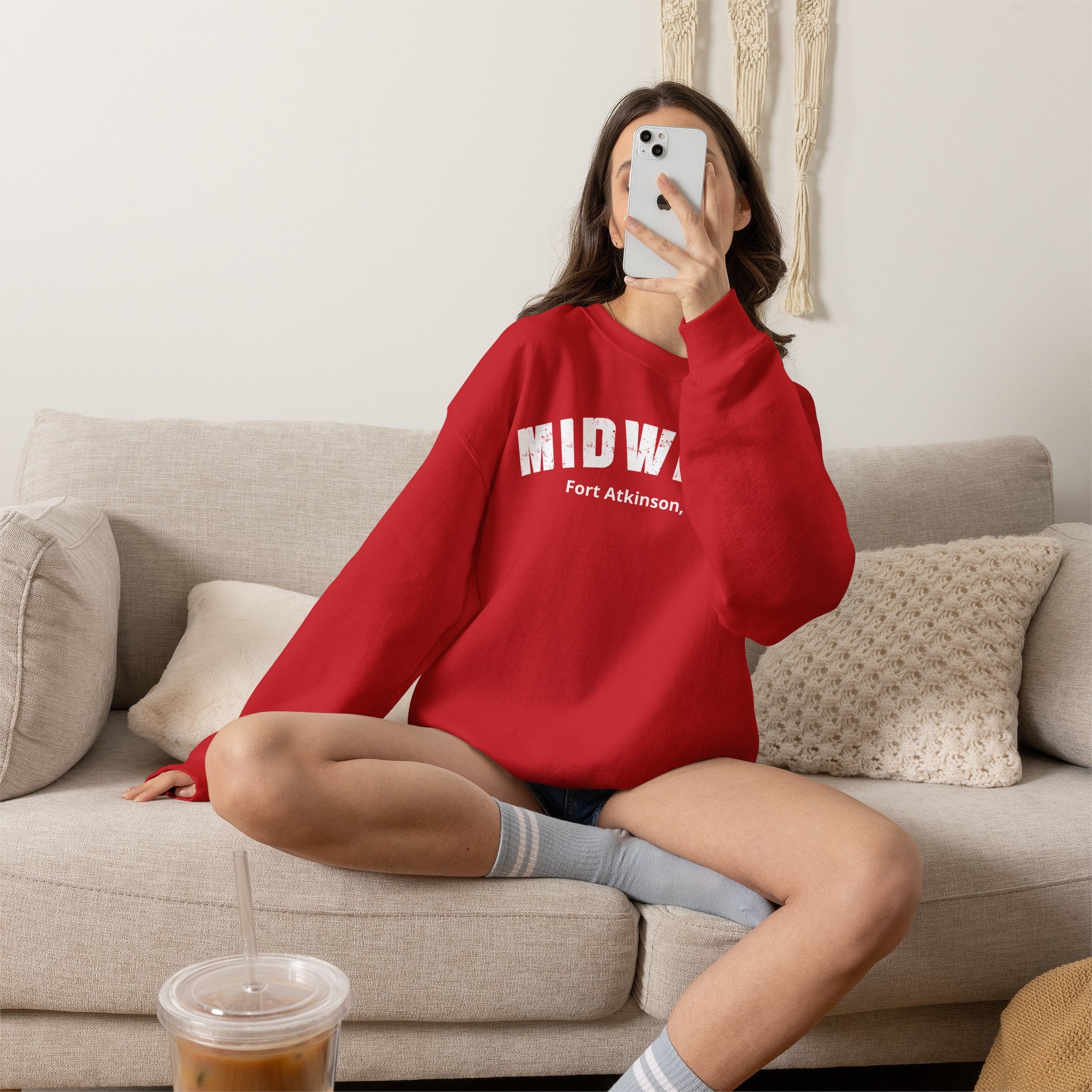 Woman on a sofa in the Red personalized Midwest crewneck sweatshirt