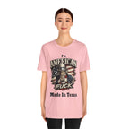 Pink tee worn by female model, close-up, Uncle Sam graphic with "I'm American As Fuck, Made In Texas" text