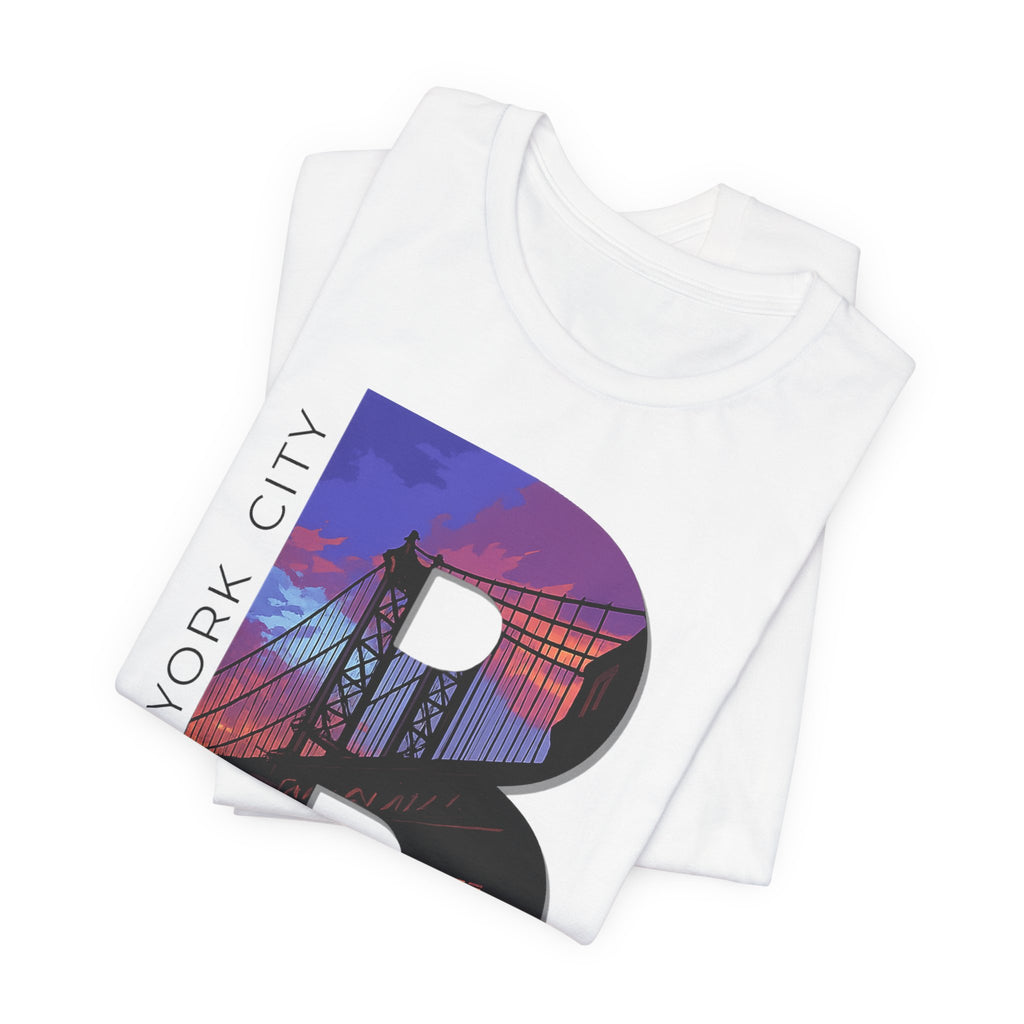 Folded stack of White tees, close-up angle of the "B" Brooklyn Bridge sunset skyline chest print design.
