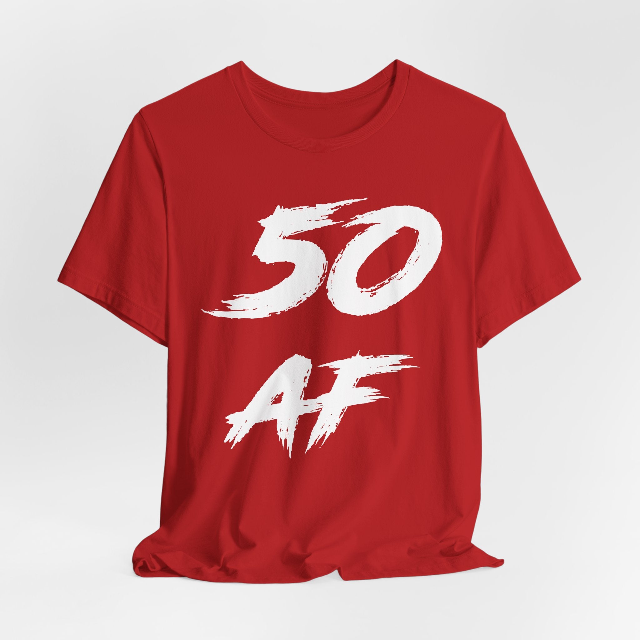 Red birthday t-shirt laid flat and slightly rumpled, white 50 AF front graphic