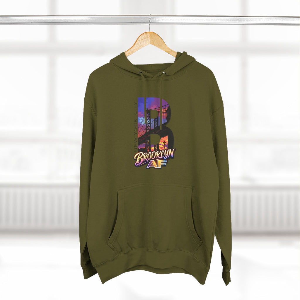Army green hoodie hanging on a wooden hanger, bold B with a Brooklyn Bridge sunset skyline graphic and Brooklyn AF logo.