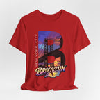 Red t-shirt flat lay, front view with full 'B' graphic, Brooklyn Bridge sunset skyline and 'Brooklyn AF' logo