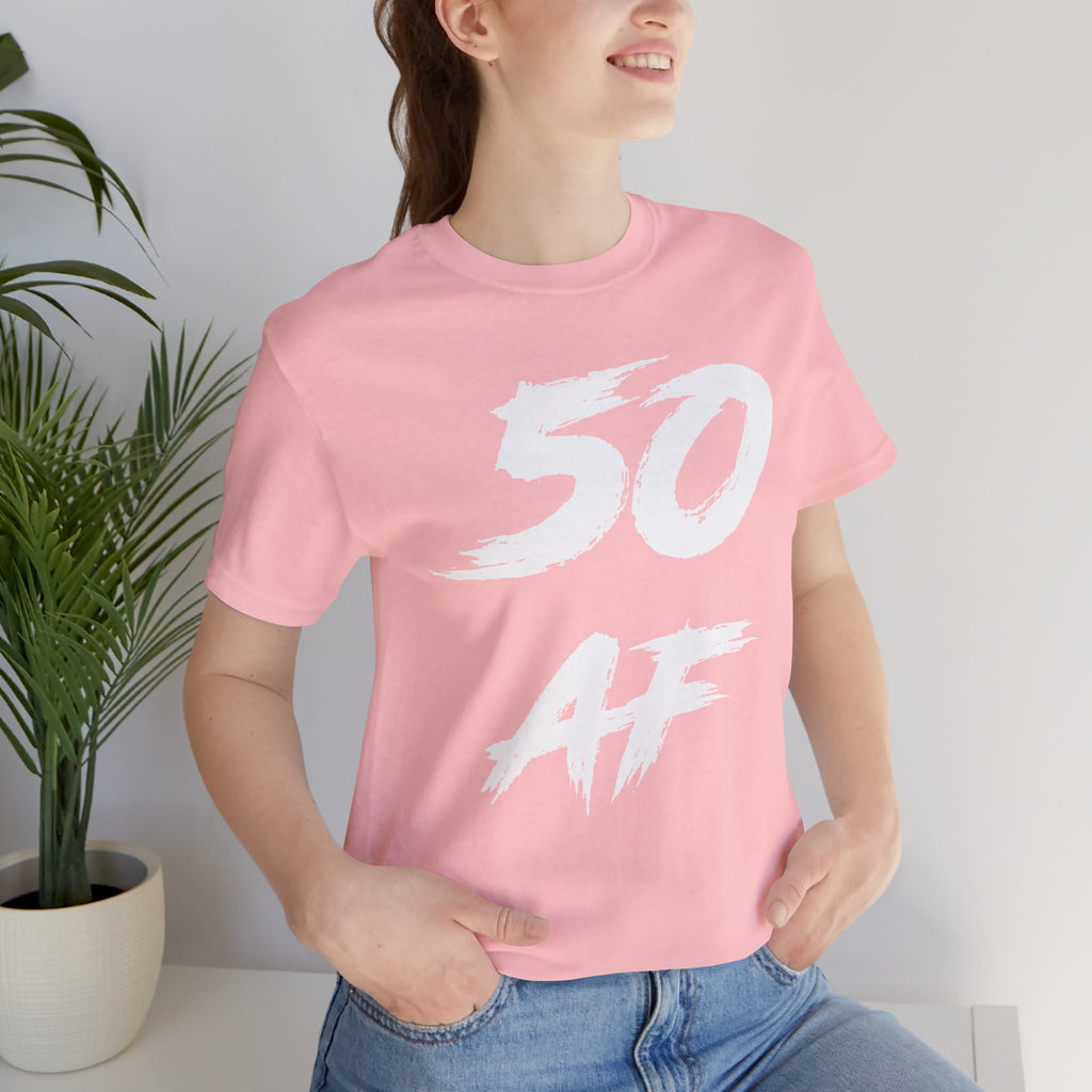 Woman indoors by a plant wearing the pink 50 AF birthday tee