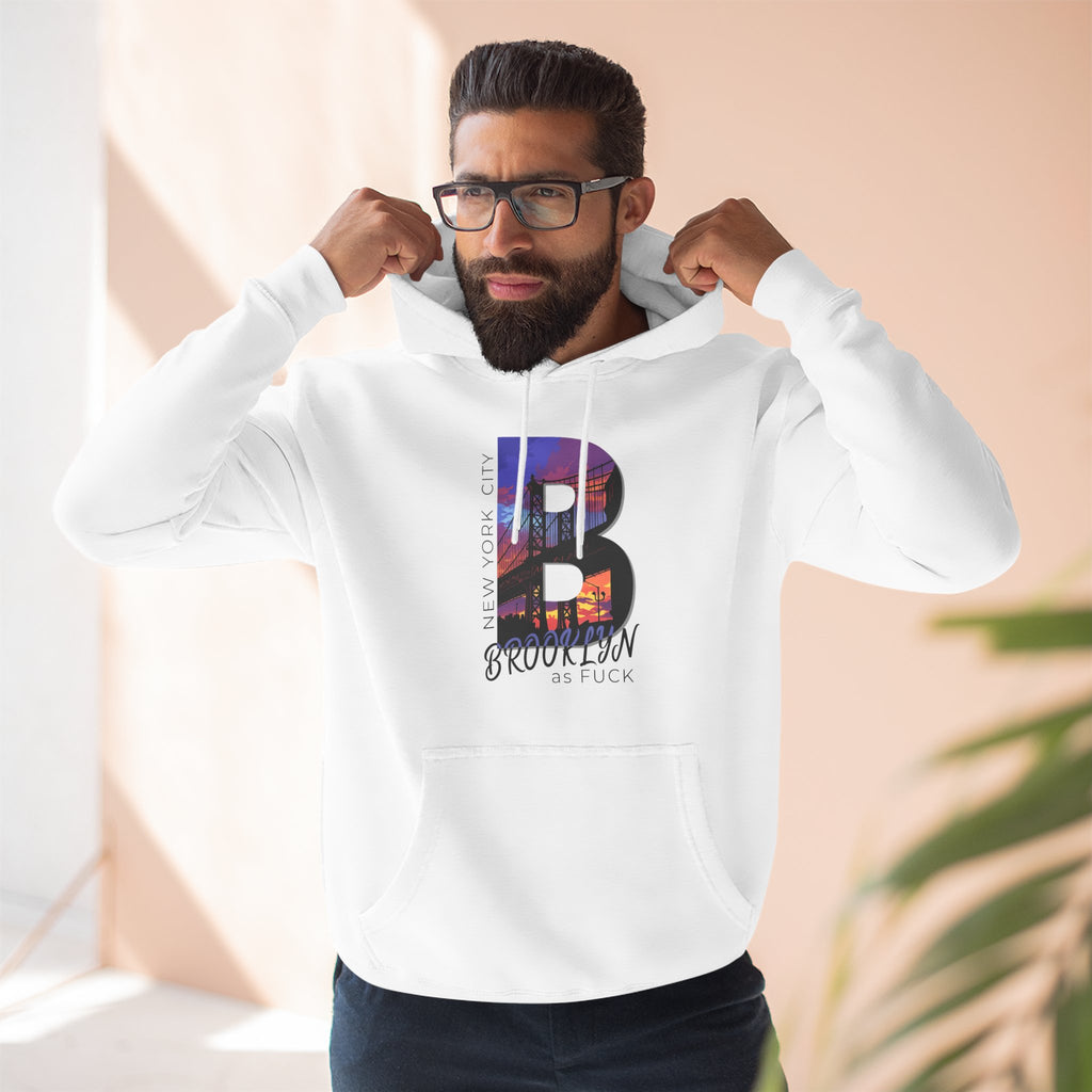 White hoodie worn by a bearded male model adjusting his hood, close-up chest view, with the 'B' Brooklyn skyline graphic.