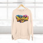 Sandshell hoodie hanging on a wooden hanger, showing the colorful graffiti-style Brooklyn AF skyline print.