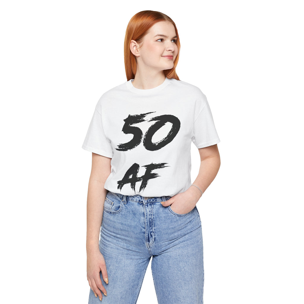Red-haired woman in the white 50 AF birthday tee and blue jeans, black front print