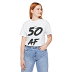 Red-haired woman in the white 50 AF birthday tee and blue jeans, black front print