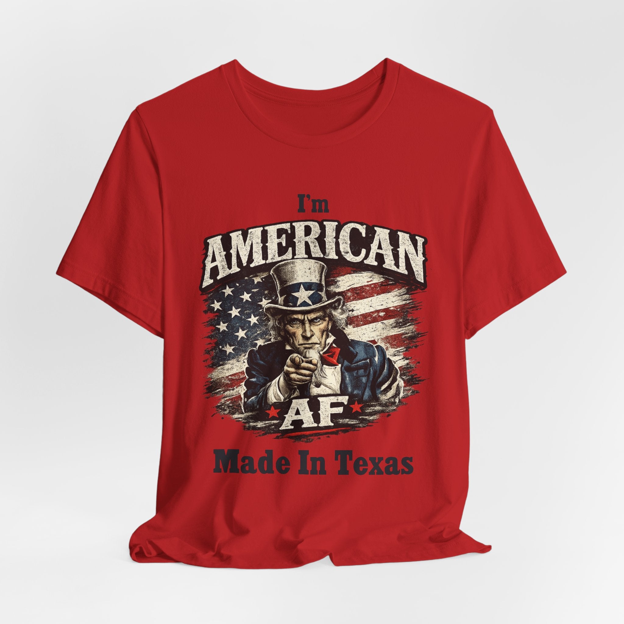 Red flat lay tee with relaxed folds, Uncle Sam pointing graphic and 'I'm American AF, Made In Texas' text