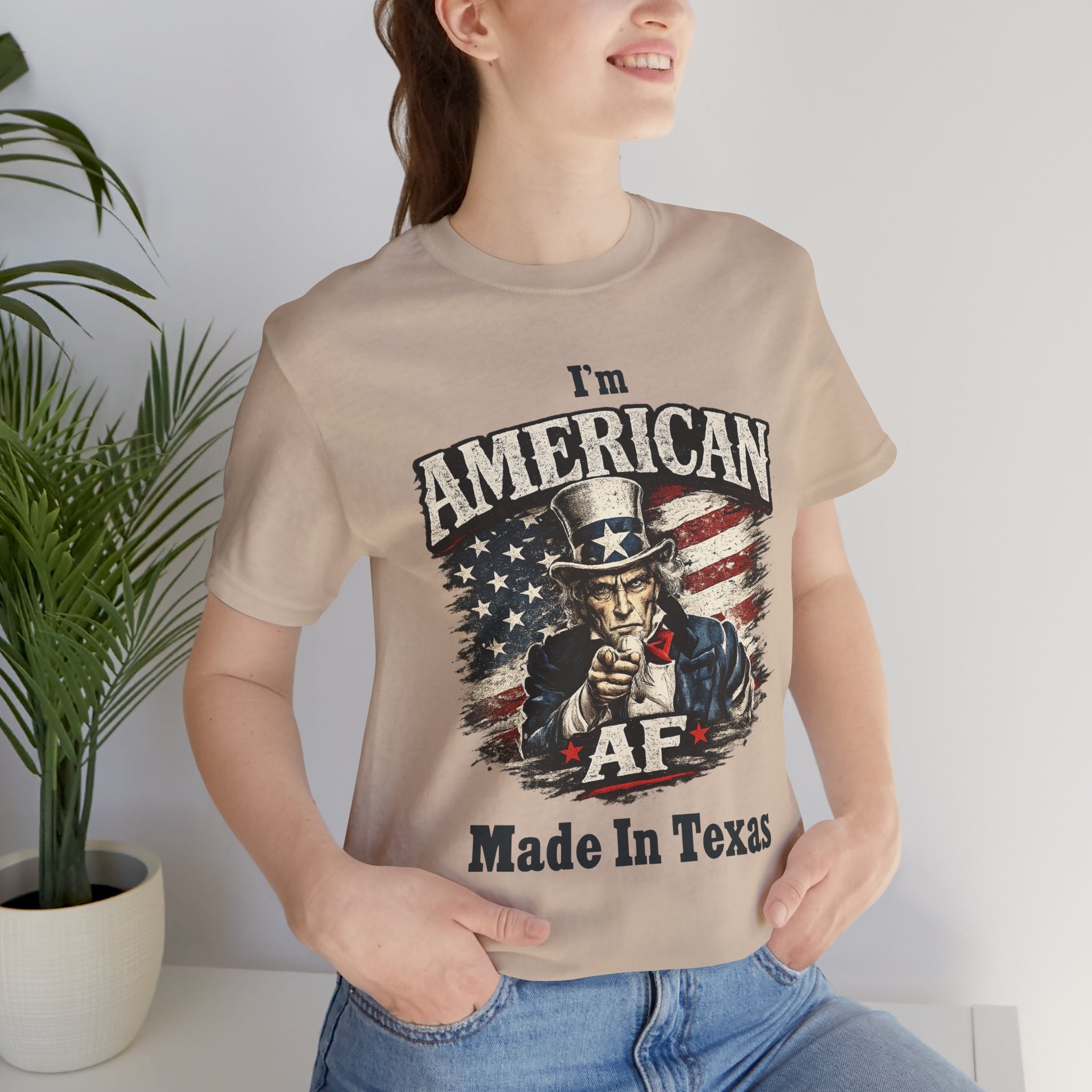 Close-up of a female model in a tan tee with the Uncle Sam graphic and 'Made In Texas' text