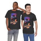 Two models wearing dark grey heather t-shirts, front view, both featuring the 'B' Brooklyn Bridge sunset skyline graphic