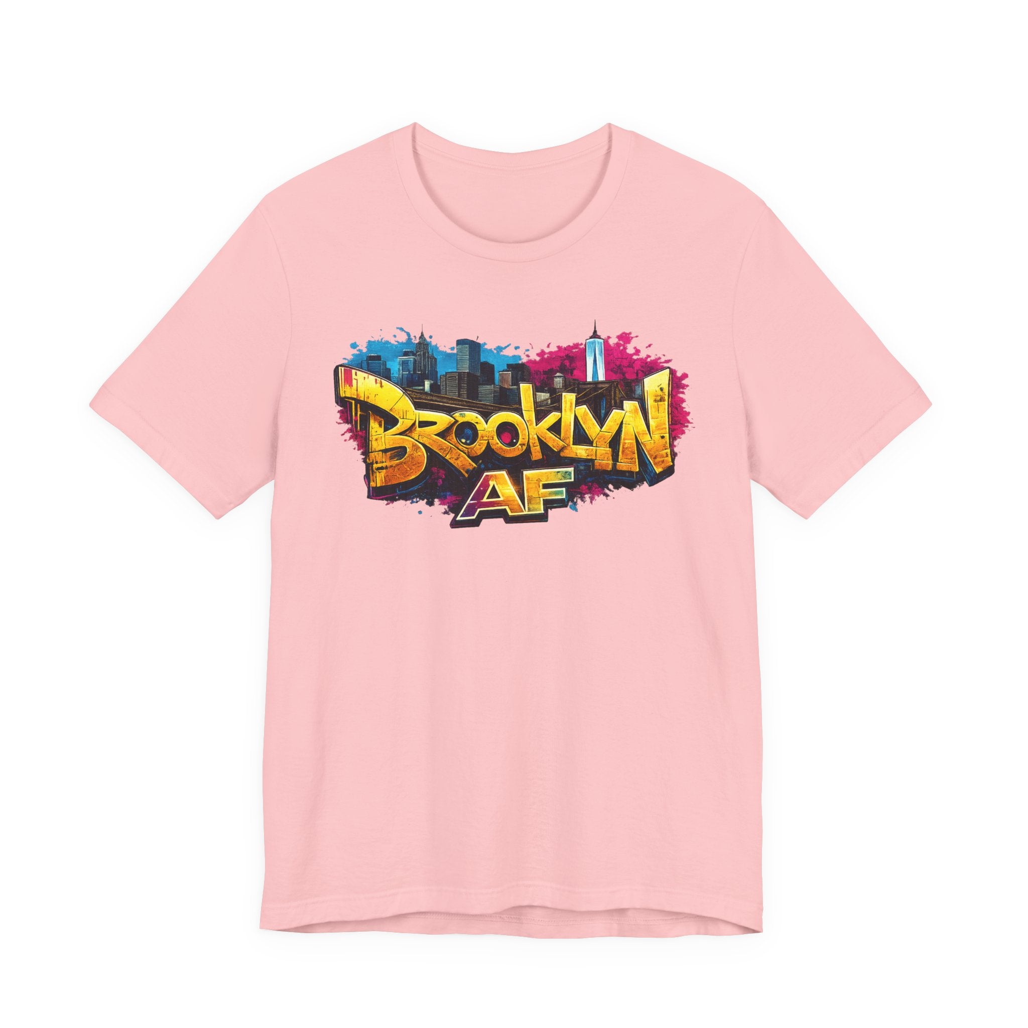 Pink t-shirt, front view flat lay, with graffiti-style Brooklyn AF lettering over a skyline paint-splash design.