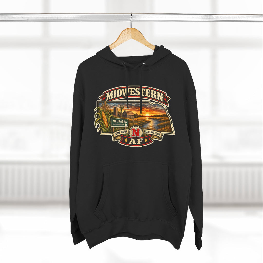 Black Nebraska hoodie on a wooden hanger, front print lit by window light