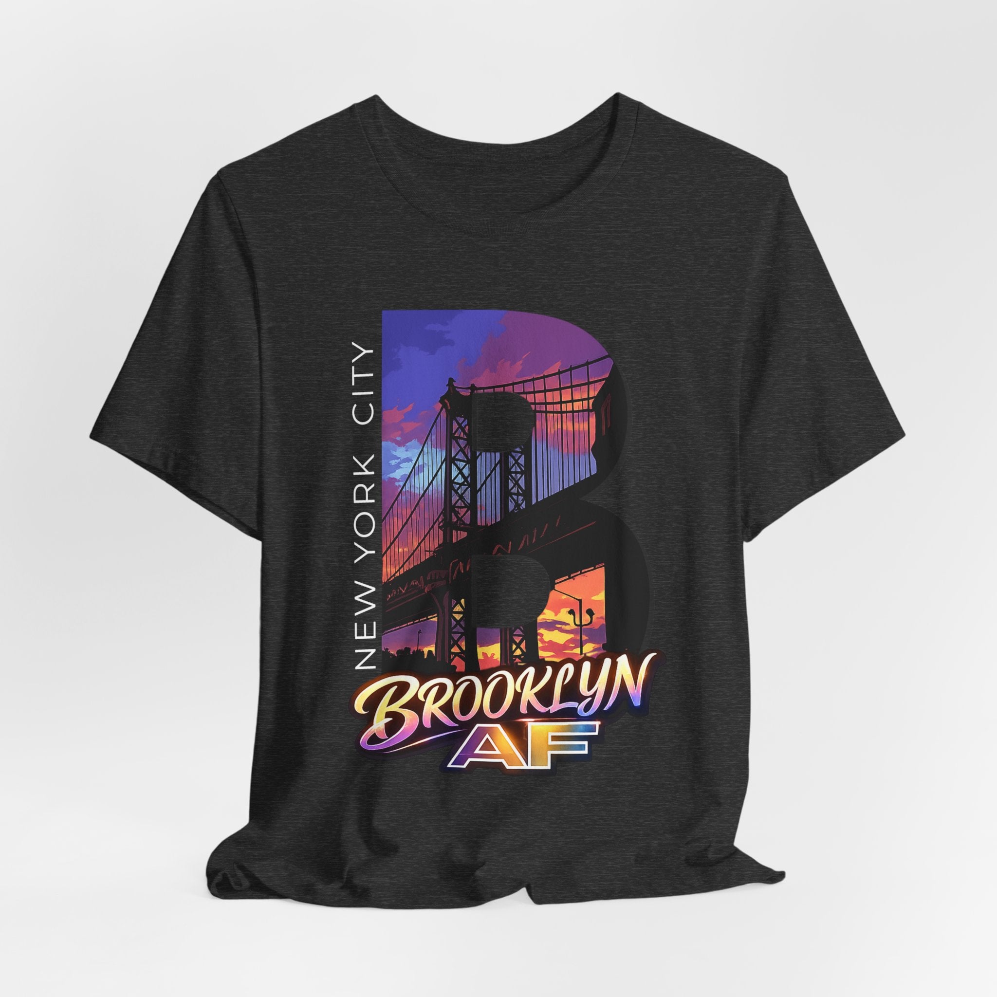 Dark grey heather t-shirt, flat lay front view, with a bold B and a purple-orange Brooklyn Bridge sunset skyline graphic.