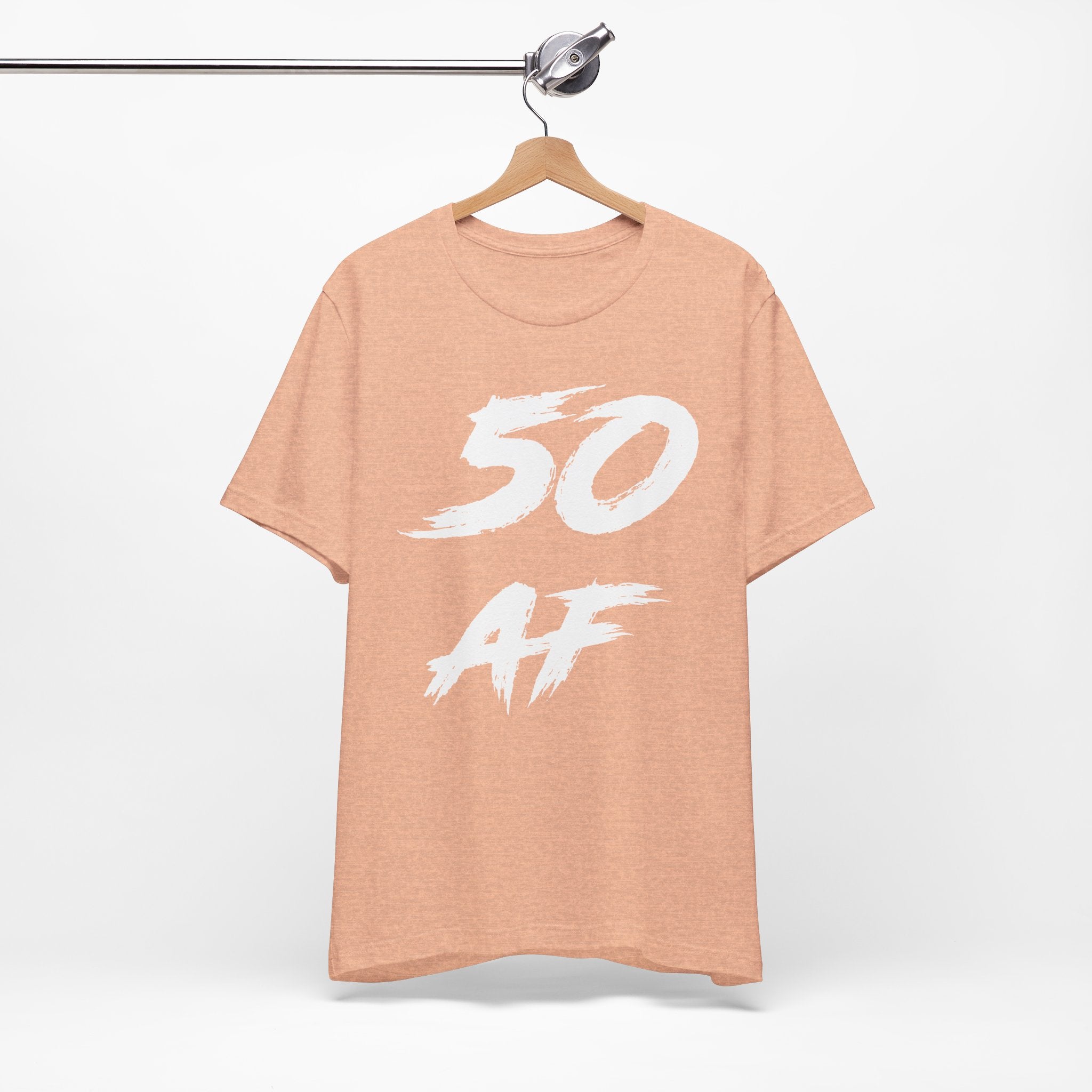 Heather Peach 50 AF birthday tee on a wooden hanger showing the white front print