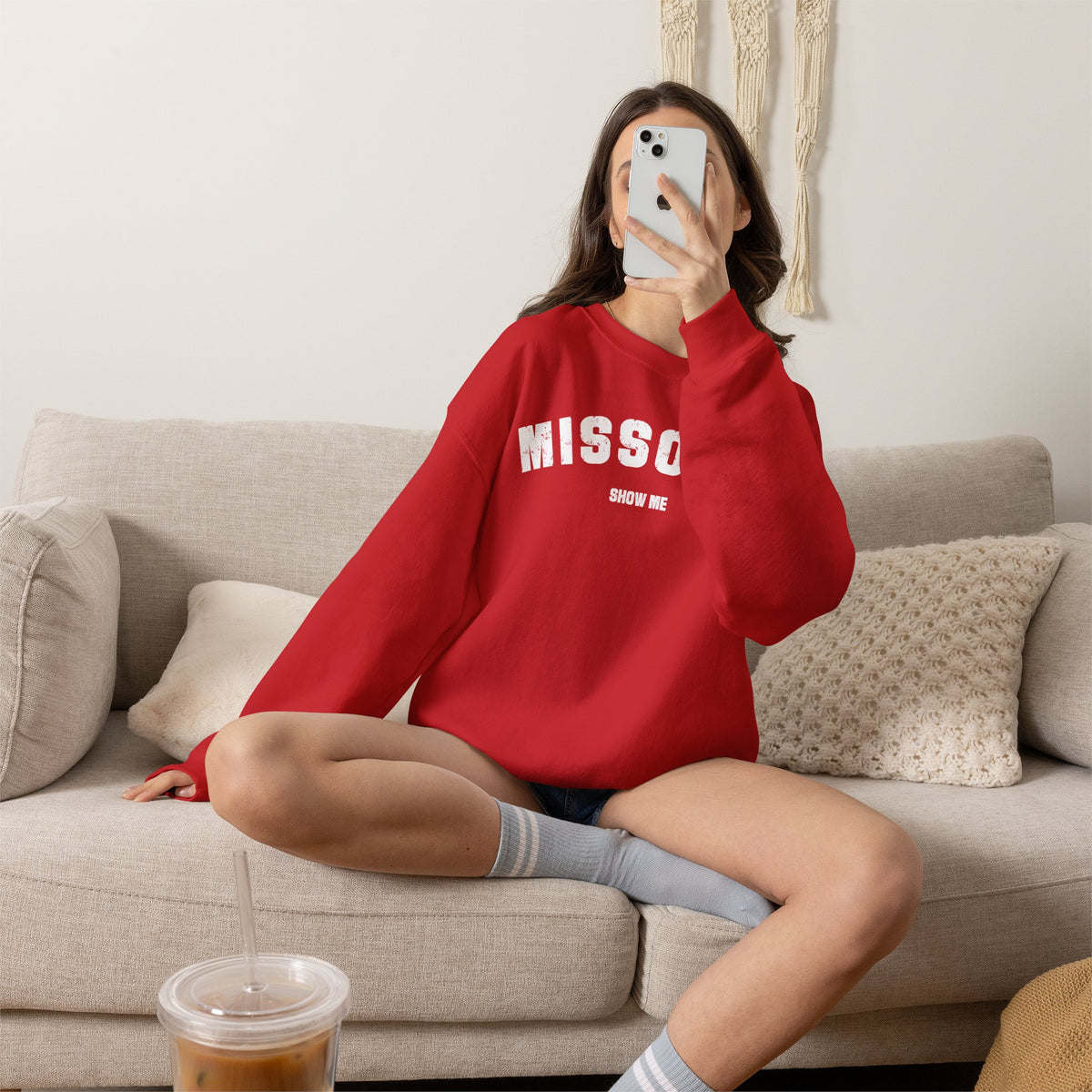 Woman relaxing on a sofa in the red personalized Missouri sweatshirt with varsity MISSOURI lettering