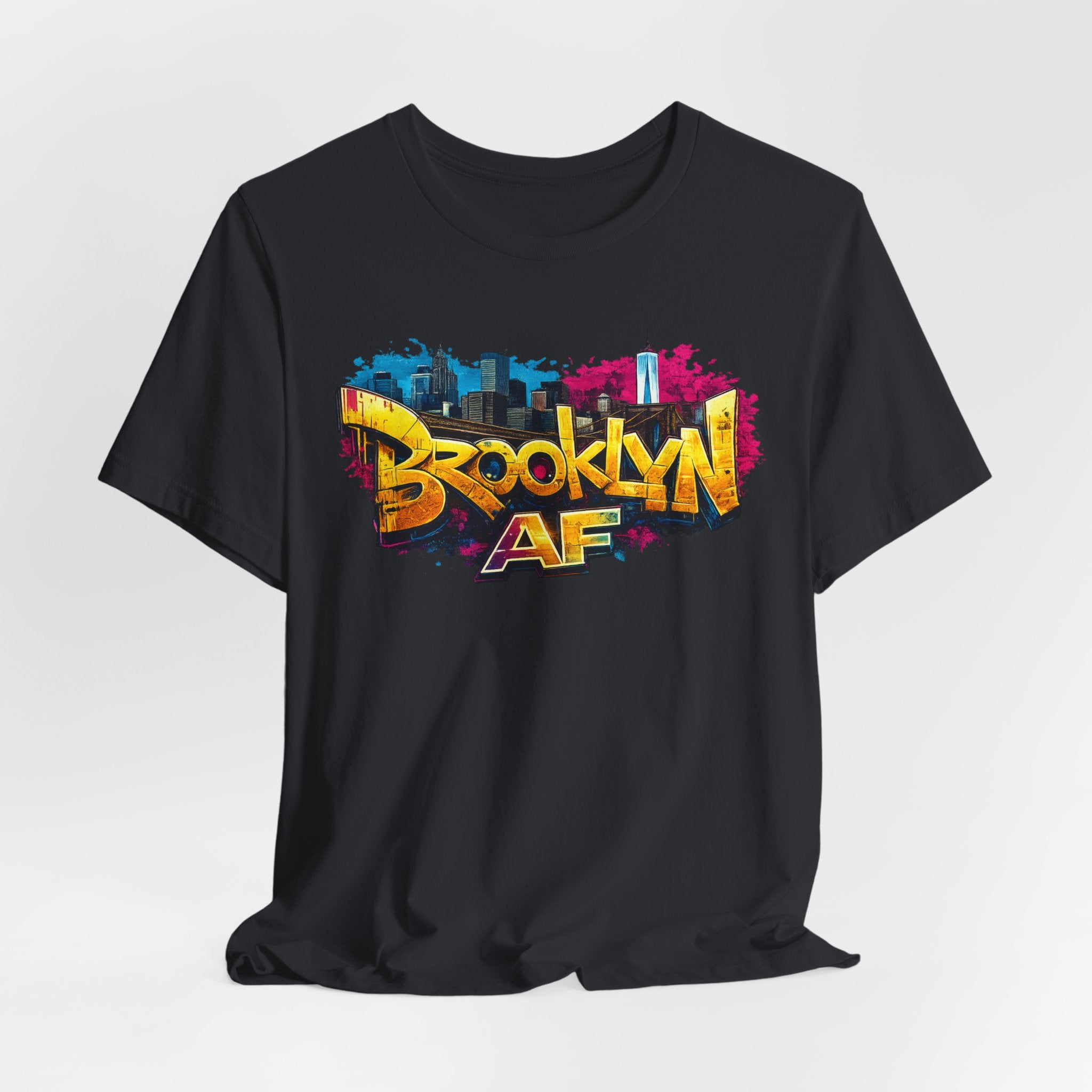 Black t-shirt, front view flat lay, showing graffiti Brooklyn AF lettering over a skyline with paint-splash design.