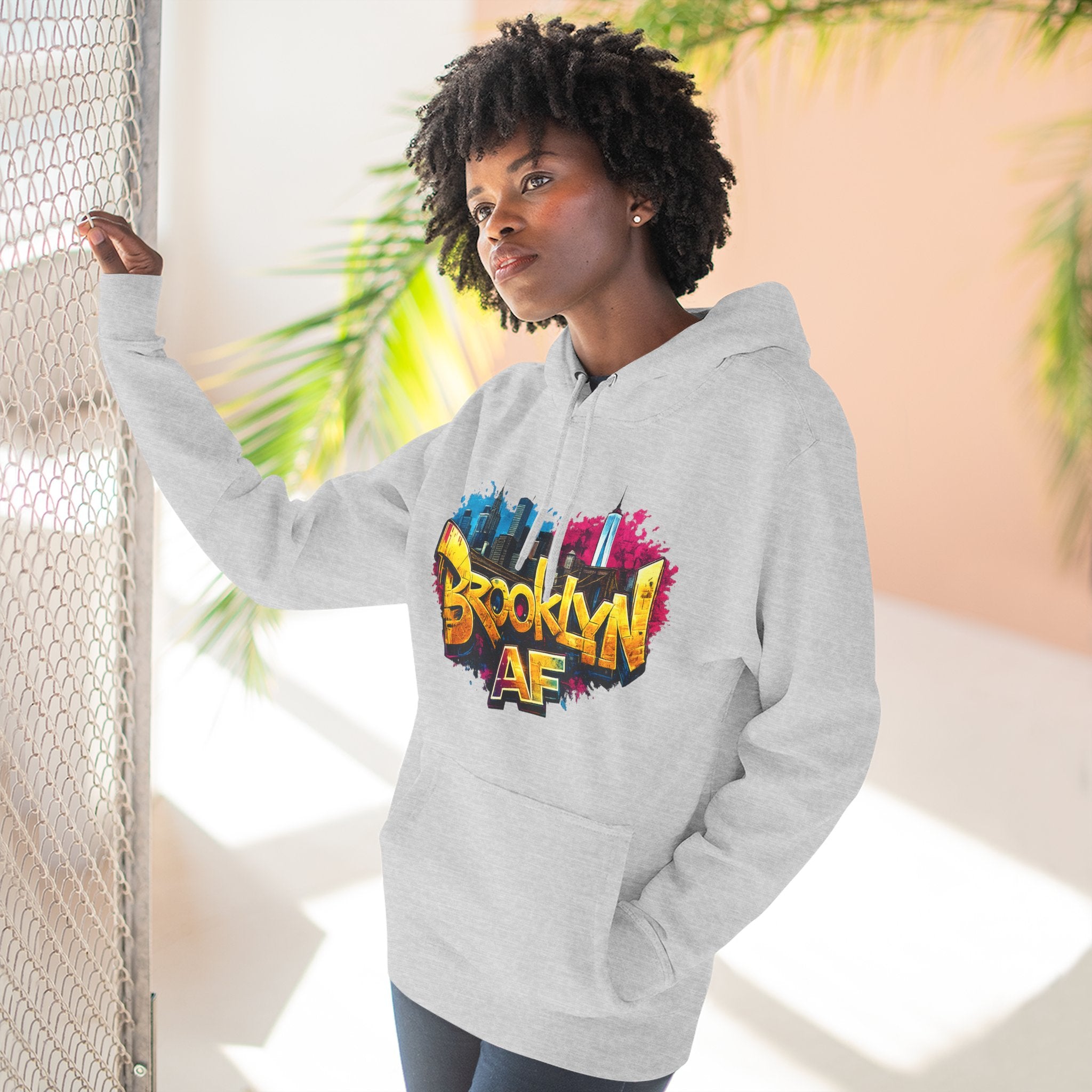 Heather Grey hoodie worn by a female model, front view, showing the colorful graffiti-style Brooklyn AF skyline print.