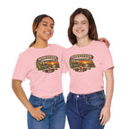 Two women in pink Nebraska tees showing the Midwestern AF cornfield and sunset front print