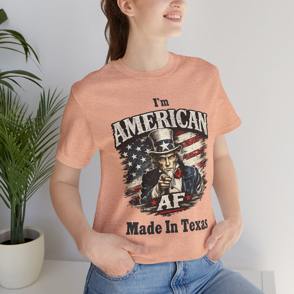 Close-up of a female model in a heather peach tee with the Uncle Sam graphic and 'Made In Texas' text