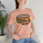 Heather peach Nebraska tee worn indoors, close on the Midwestern banner over a Nebraska-shaped farm scene