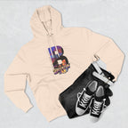 Oatmeal heather hoodie styled with black jeans, belt, and sneakers, bold B featuring a Brooklyn Bridge skyline graphic.