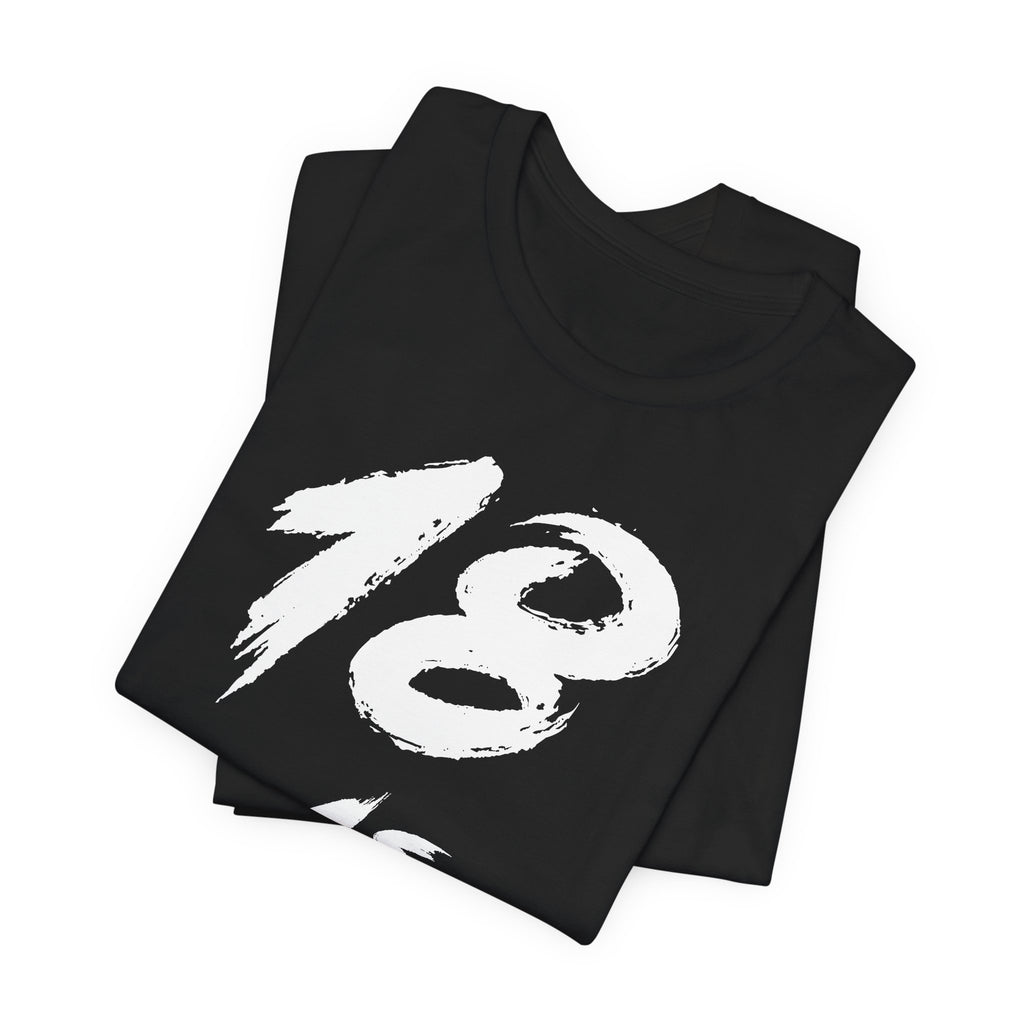 Folded black birthday tees stacked, the white 18 filling the top fold