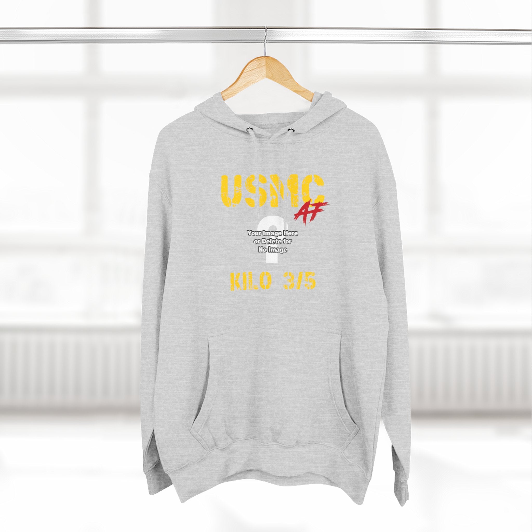 Woman wearing the Personalized USMC Marine Corps AF hoodie in Heather Grey beside a sunlit window