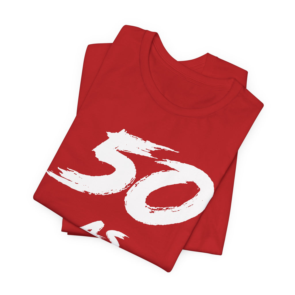 Folded red birthday tees stacked with the white 50 print across the top fold