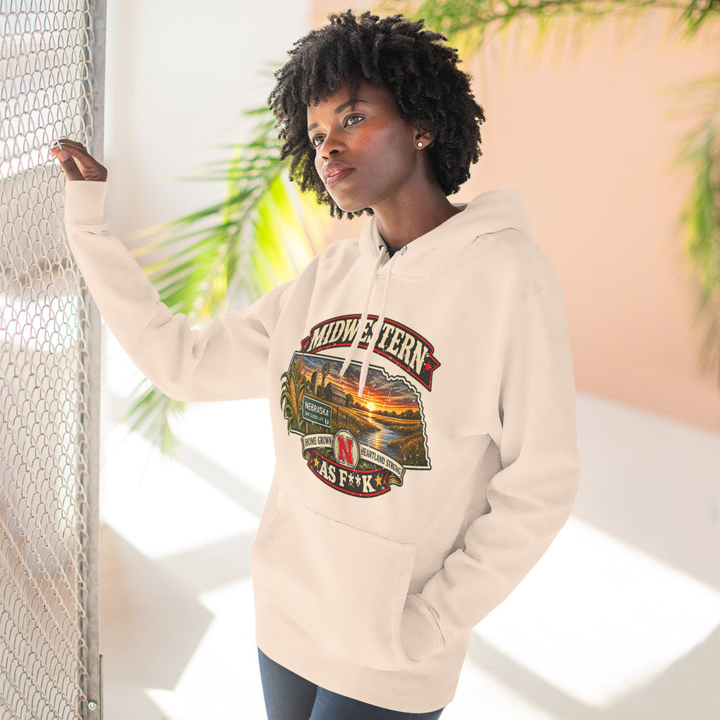 Woman in the pale pink Nebraska As F**K hoodie leaning against a fence outdoors
