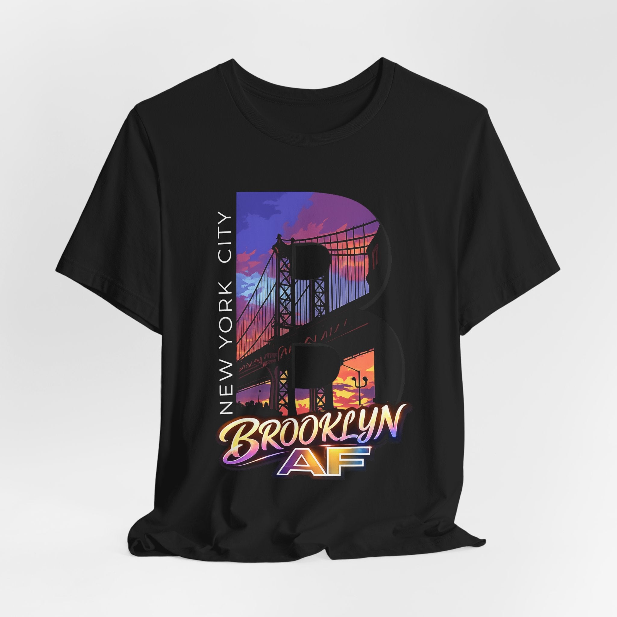 Black t-shirt, flat lay front view, with a bold B and a purple-orange Brooklyn Bridge sunset skyline graphic.