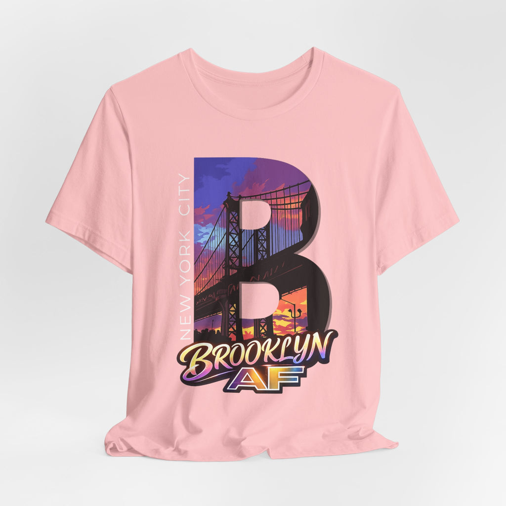 Pink t-shirt flat lay, front view with full 'B' graphic, Brooklyn Bridge sunset skyline and 'Brooklyn AF' logo