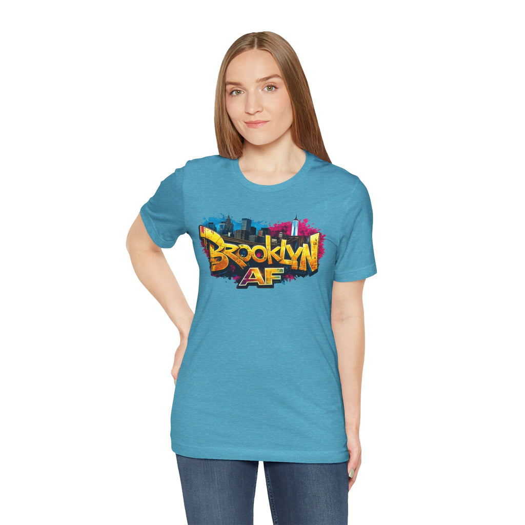 Heather Aqua t-shirt worn by a female model, front view, showing graffiti Brooklyn AF lettering over a skyline.