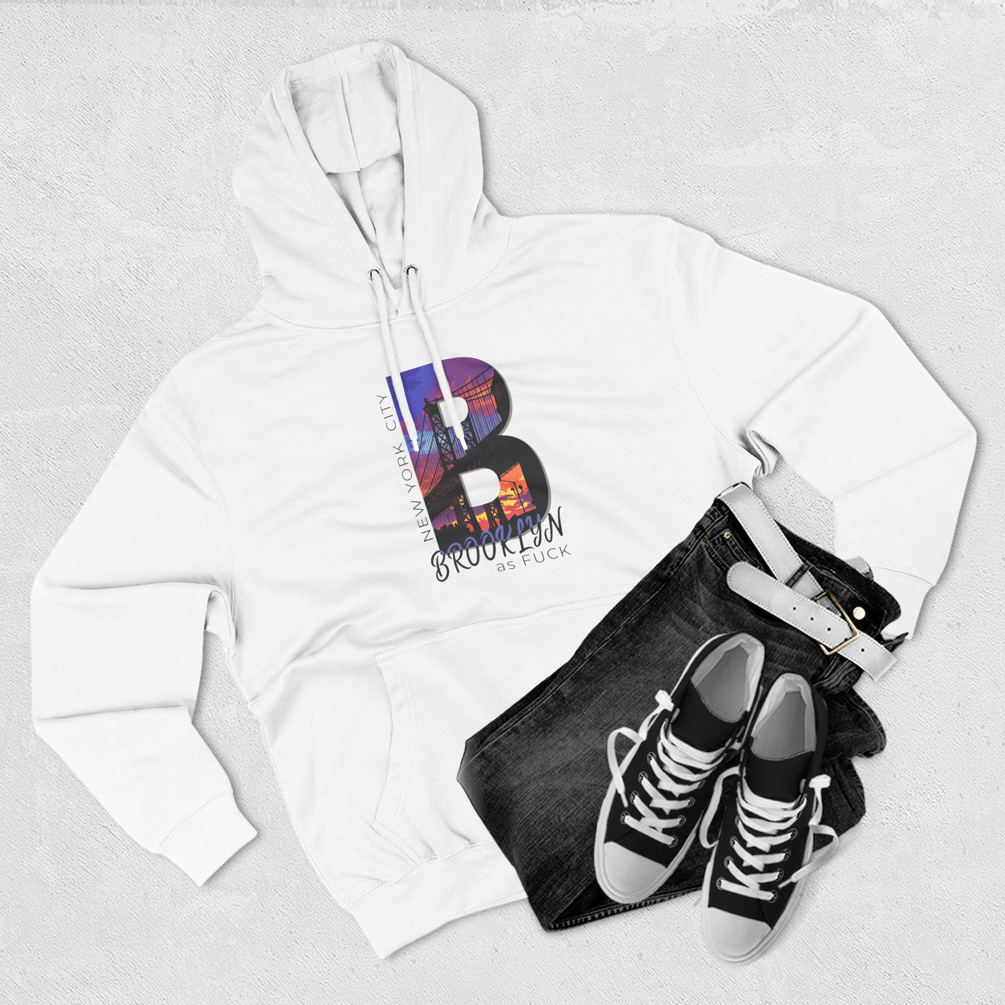 White hoodie, flat lay styled with jeans and sneakers, showing the 'B' Brooklyn skyline graphic and 'As Fuck' text.