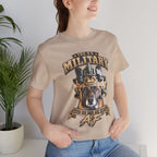 Woman wearing the Military K-9 T-shirt in Tan beside a potted plant