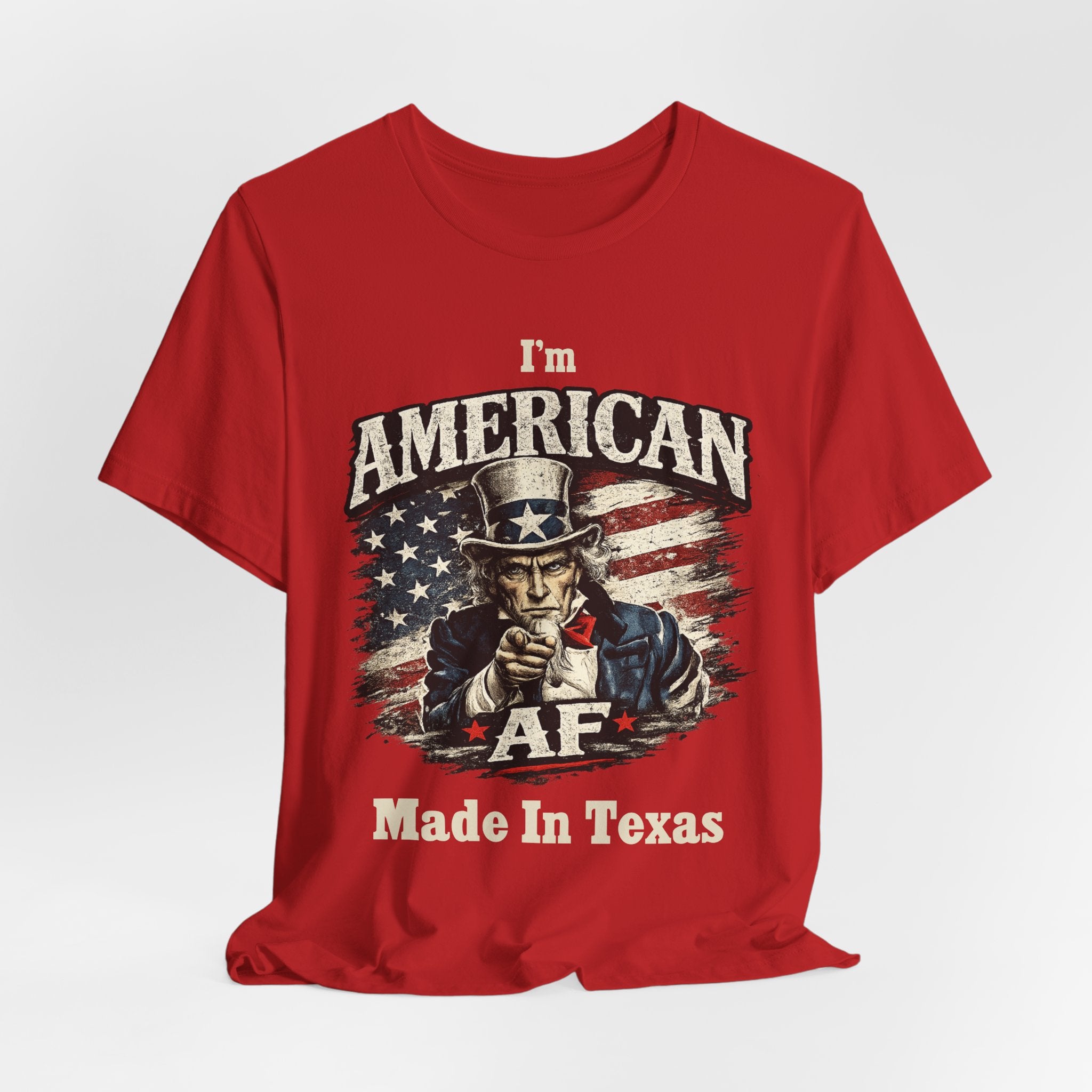 Red t-shirt casually draped with soft folds, showing the Uncle Sam graphic and AF Made In Texas text.