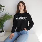 Woman seated beside a houseplant in the Black custom Midwest crewneck and jeans