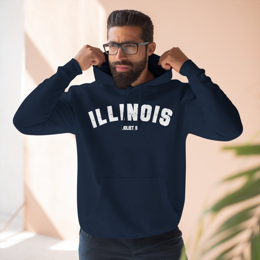 Man pulling up the hood of a Navy custom Illinois hoodie, white ILLINOIS above a Joliet IL line
