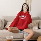 Woman on a couch wearing the Red personalized Nebraska sweatshirt with distressed varsity lettering