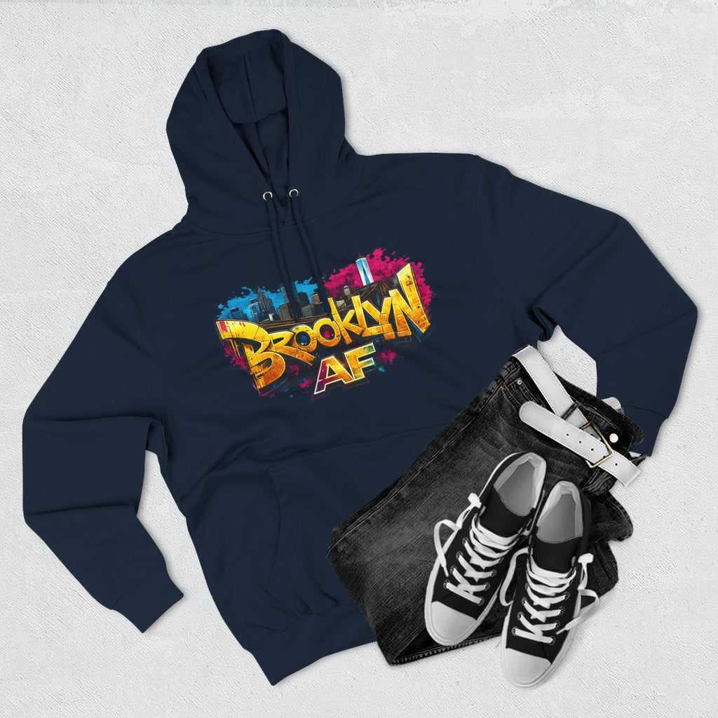 Navy hoodie flat lay styled with black jeans and sneakers, showing the graffiti-style Brooklyn AF skyline print.