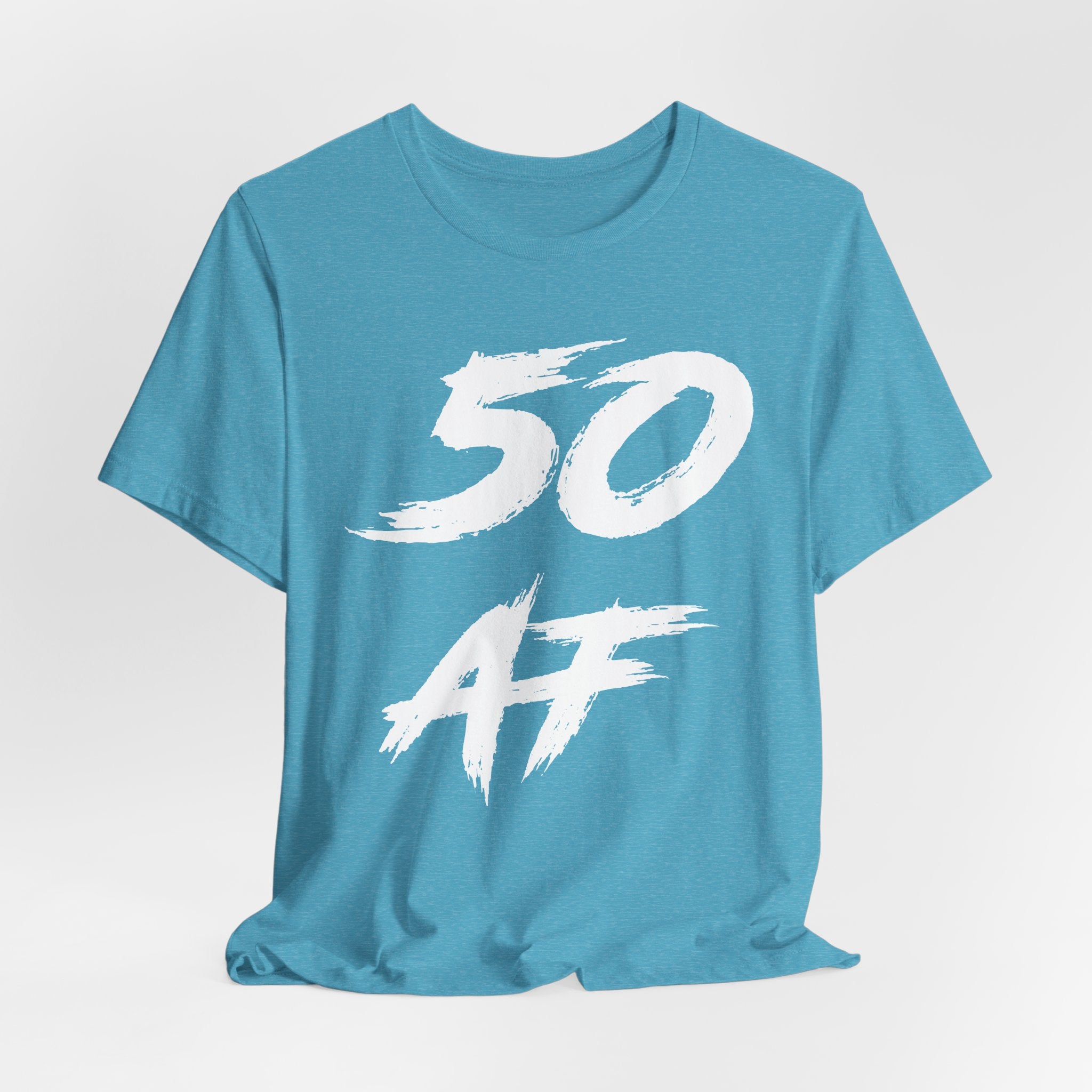 Close crop of the Heather Aqua tee laid flat, white 50 AF brush strokes in detail