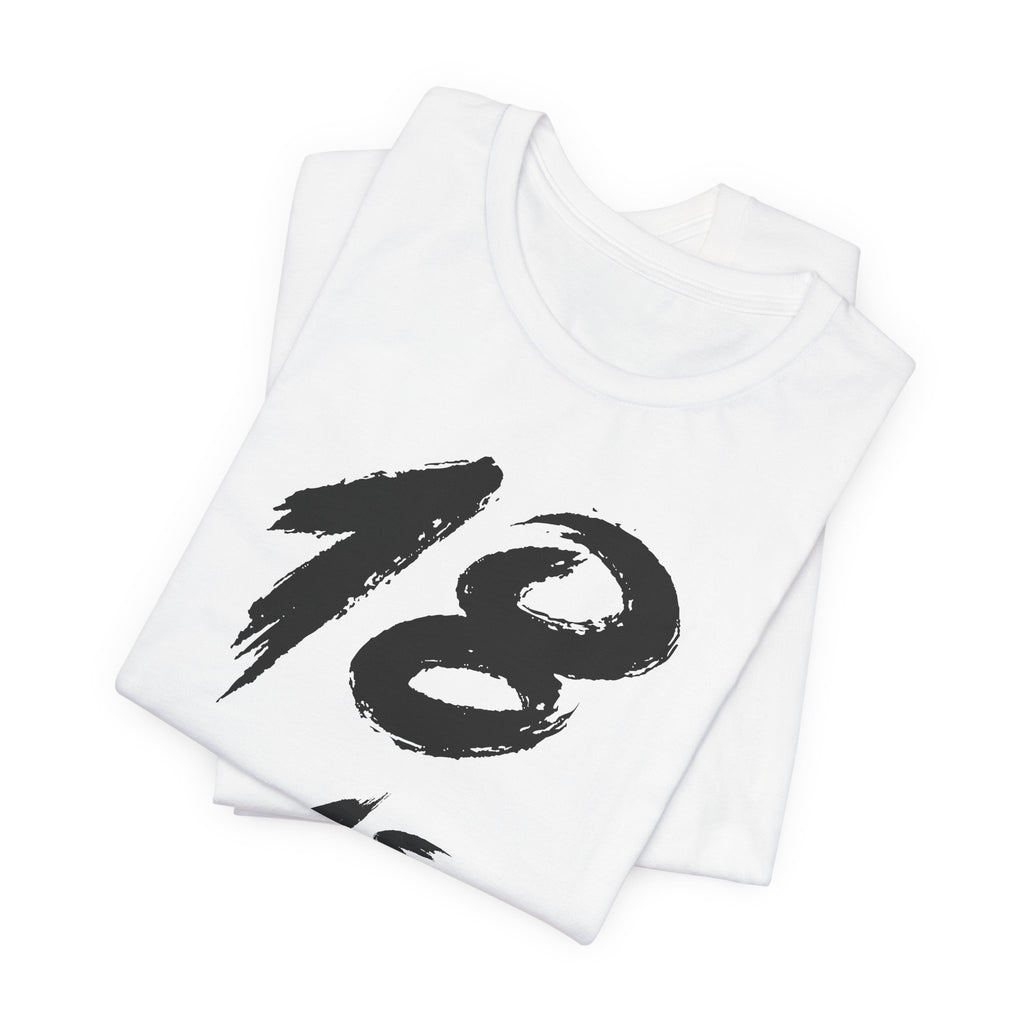 Folded white birthday tees stacked, the black 18 showing on the top fold