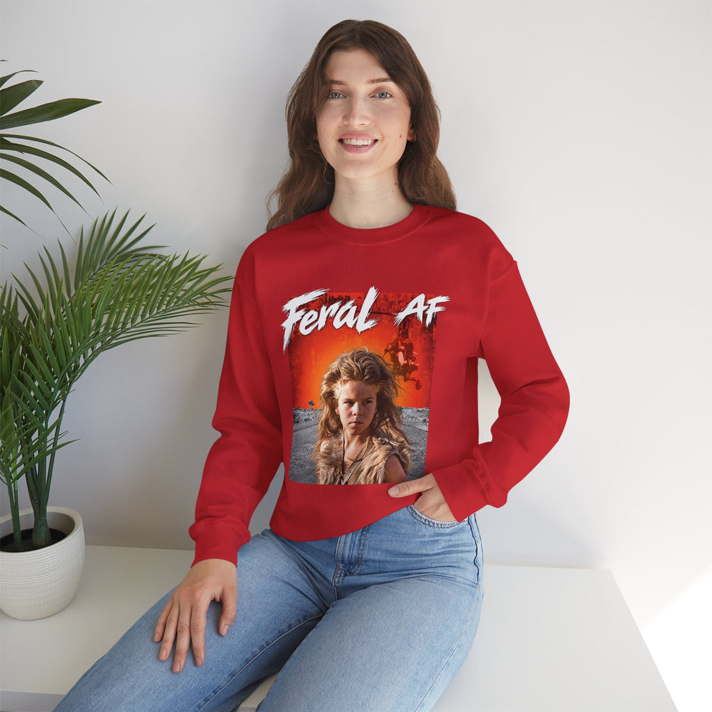 Woman seated beside a potted palm in the Red Feral AF sweatshirt, front graphic centred