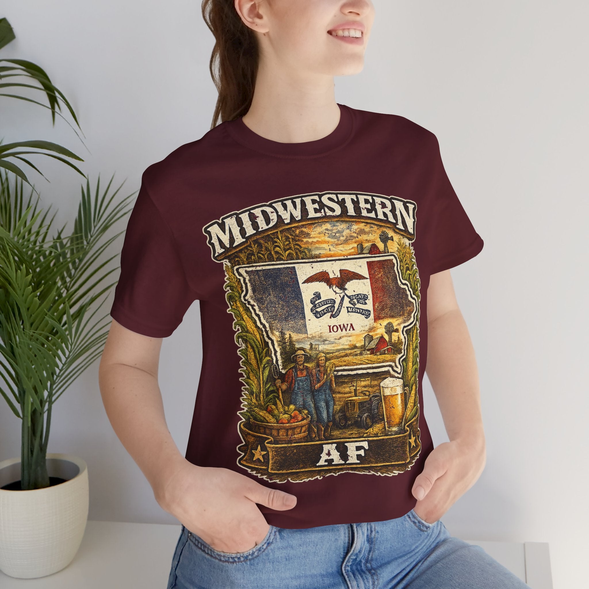 Family Friendly Midwestern AF Iowa T-Shirt – product photo 15 featuring a distressed vintage design featuring the outline of Iowa overlaid with the Iowa state flag, surrounded by towering corn stalks, rolling farmland, a classic red barn, a windmill, a tractor, and an overflowing harvest basket