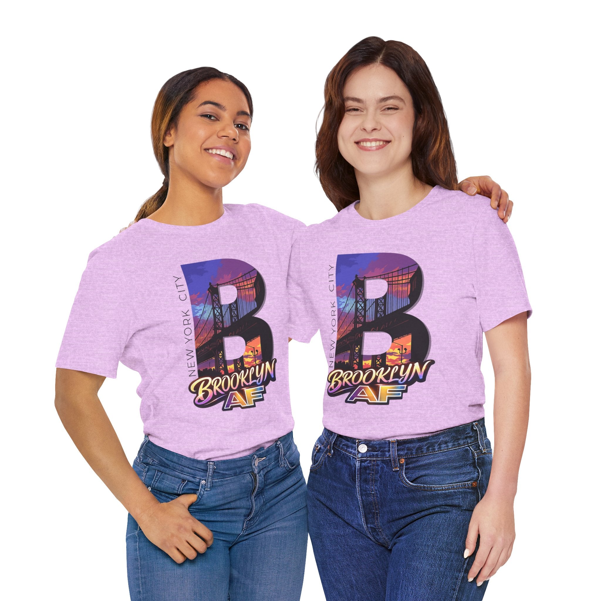 Light lilac t-shirts worn by two female models, front view, each with a bold "B" Brooklyn Bridge sunset skyline graphic.