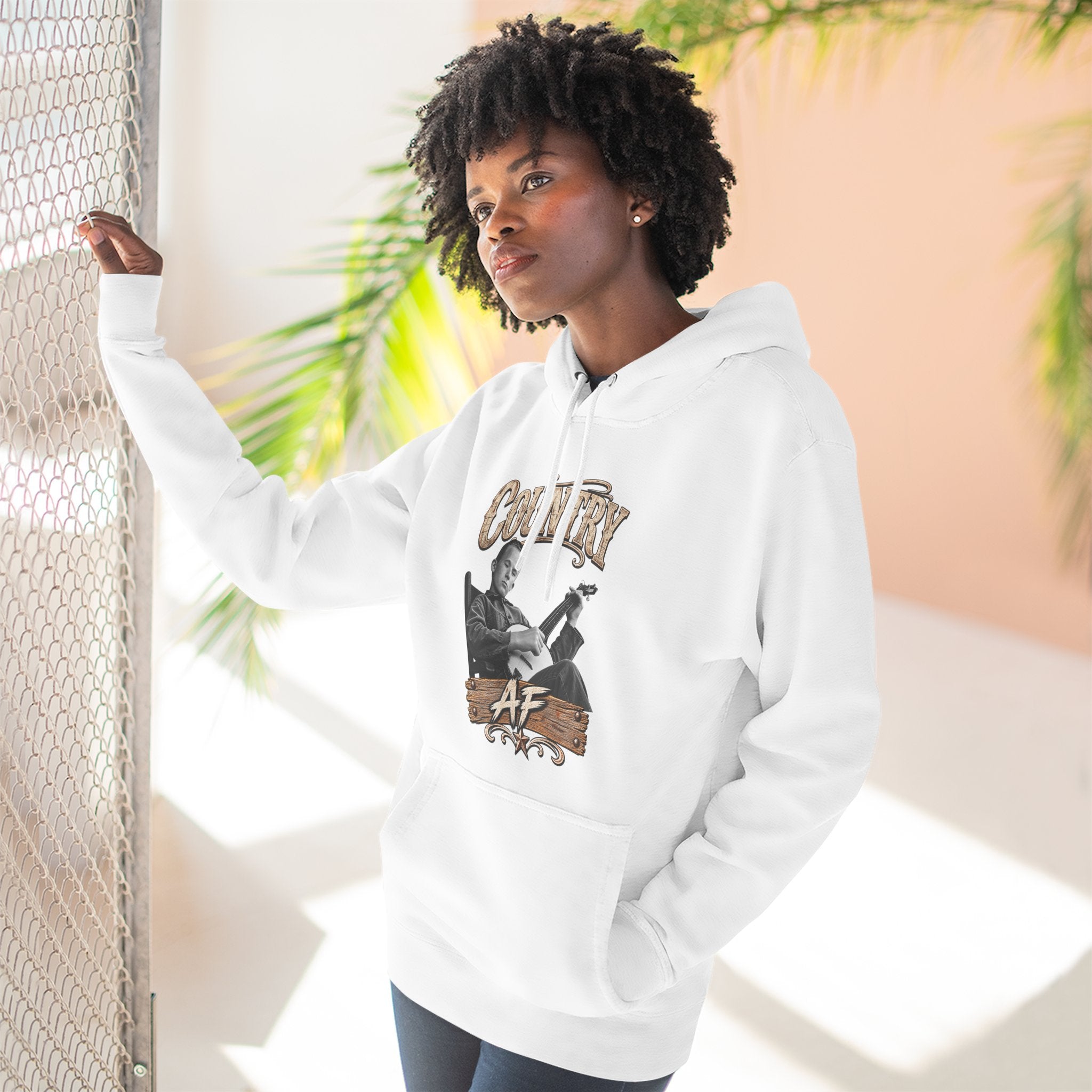 Woman at a sunlit window in the White Country AF hoodie